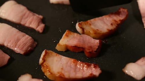 Frying smoked bacon on frying in pan