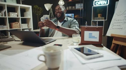 Fröhlicher afroamerikanischer Geschäftsmann hält Dollarscheine Late Night Office