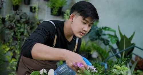 Jardinier mâle utilisant un vaporisateur pour arroser les plantes à feuilles