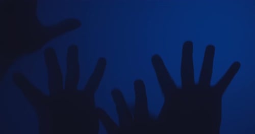 Silhouetted Hands Reach Up on Blue Background