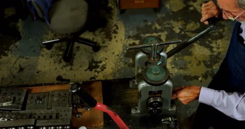 Goldsmith working on machine in workshop 4k