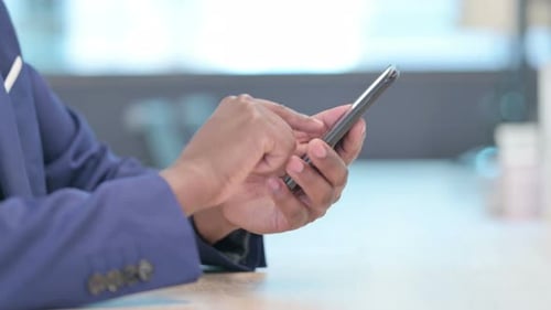 Close Up of Hands of African Businessman Using Smartphone