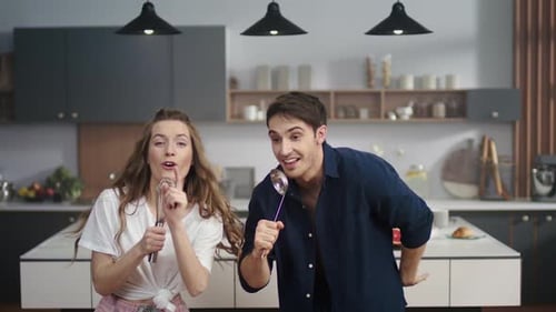Energetic Couple Singing and Dancing in Kitchen
