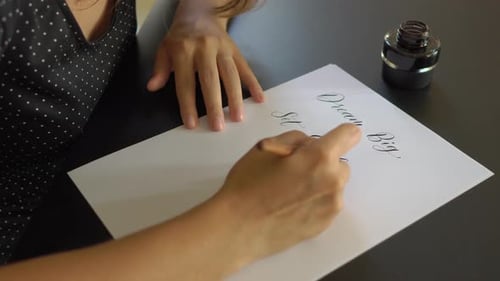 Close Up Shot of a Young Woman Calligraphy Writing on a Paper Using Lettering Technique. She Writtes