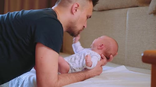 Loving Father Interacts with Crying Infant Son