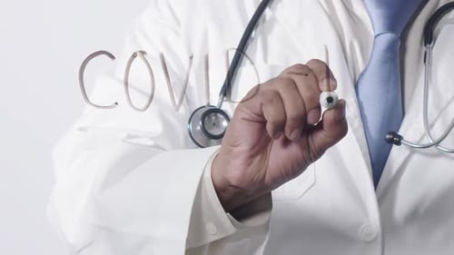Doctor Writes COVID on Glass Surface