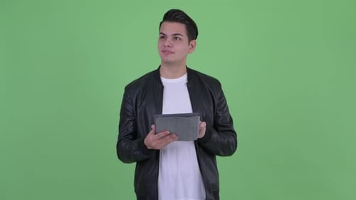 Young Man Uses Tablet on Green Screen