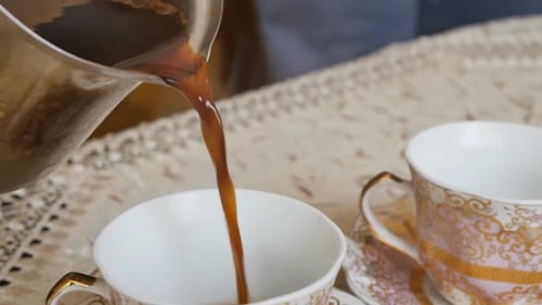 Pouring Dark Coffee Into Ornate Teacup