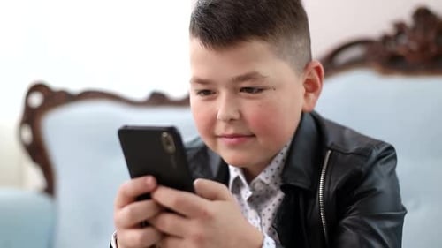 Boy Using a Smartphone Indoors