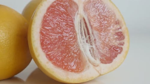Saftige rote Zitrusfrucht paradisi langsam neigt 4K 2160p 30fps UltraHD-Aufnahmen - Geschnittene Grapefruit auf Weiß