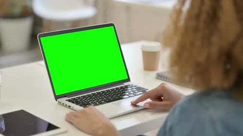 Rear View of African Woman Using Laptop with Green Chroma Key Screen