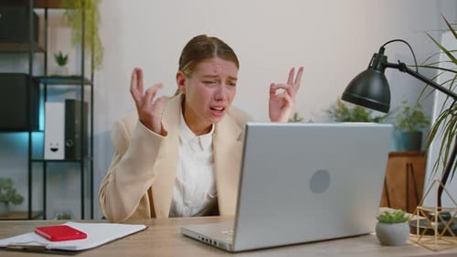 Woman Crying at Desk After Using Laptop