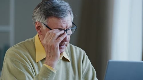 Close Up Tired Caucasian Man Indoor Working with Laptop Elderly 60s Male Take Off Glasses Rest From