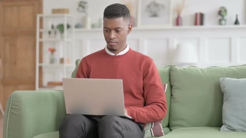 Young Adult Working on Laptop at Home