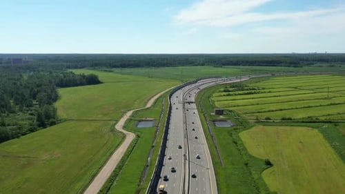 Asphalt Speedway with Cars Through Green Field. Aerial View From Drone