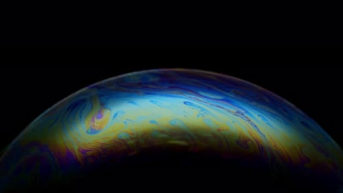 Mehrfarbige Regenbogen-Iris aus Seifenblase. Fantastischer bunter Planet auf schwarzem Hintergrund