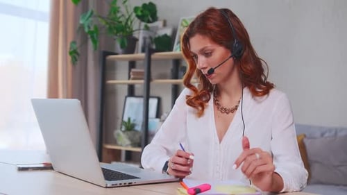 Woman Working from Home on Laptop and Headset