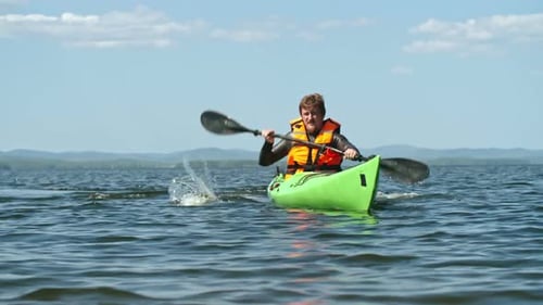 Man Kayaking on Sunny Lake Adventure