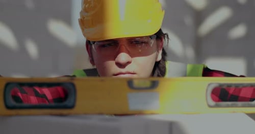 Construction Worker Using Level on White Surface