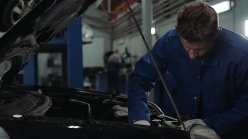Mechaniker überprüft den Ölstand in einer Autowerkstatt Mann Portrait Motor Autoreparaturdienst