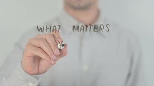 Person Writes "What Matters You?" on Glass