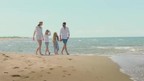 Family Enjoying Beach Walk on Summer Vacation