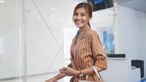 Portrait of happy young beautiful woman passenger walking in airport terminal with smile face.