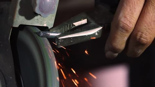 Metal Against Grinding Wheel Sparks in Close Up