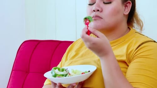 Unglückliche übergewichtige Frau, die sich von Diäten langweilt und gesundes Essen isst