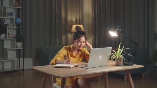 Young Adult Studying Late at Desk With Laptop