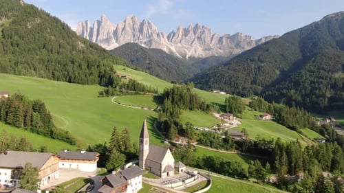 Flying over Santa Maddalena village (St Magdalena) in Dolomites mountains, Italy