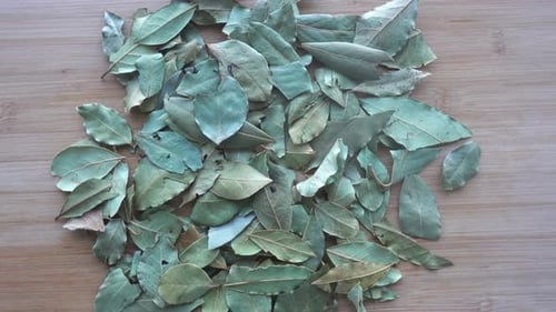 Pile of Dried Bay Leaves on Wood Surface