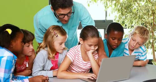 Lehrer und Kinder nutzen Laptop im Klassenzimmer
