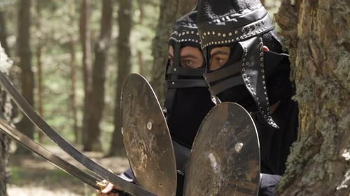 Men in Armor Hiding Behind Tree with Swords