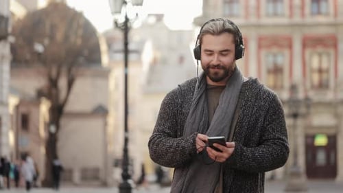 Young Adult Enjoying Music on Phone in City