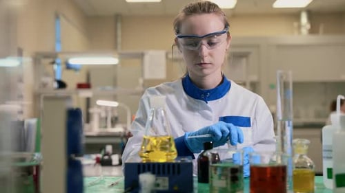 Woman Scientist Mixes Chemicals in Research Laboratory