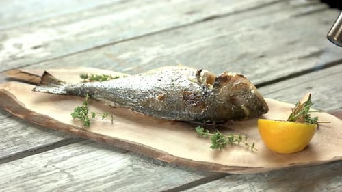 Prepared Fish Garnished with Herbs and Lemon