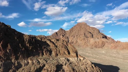 Luftaufnahme rückwärts über felsige Klippen mit Blick auf den Berg