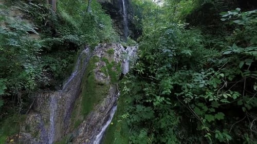 Waterfall Flows Through Lush Green Forest Setting
