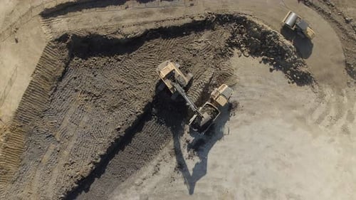 Excavator and Dump Truck Working at Construction Site