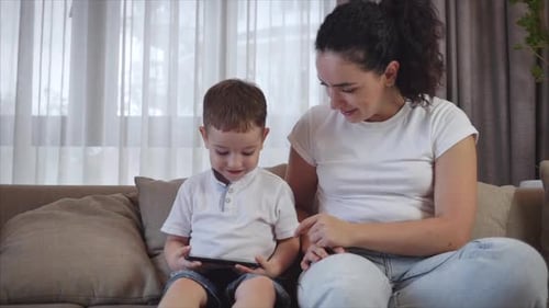 Mother and Son Using Tablet Together on Couch