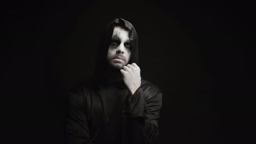 Man in Cloak and Face Paint Stares Intently