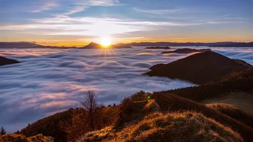 Sun Rises Over Mountains and Fluffy Cloudscape
