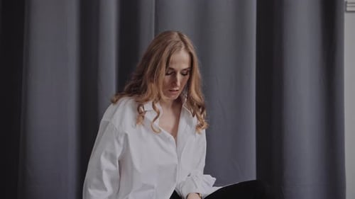 Elegant Professional Model in the White Shirt Posing To a Camera in the Studio