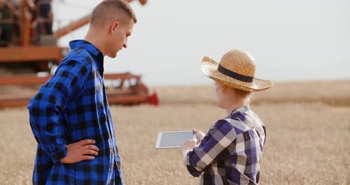 Female Farmer Discussing With Businessman On Farm