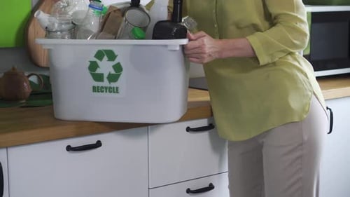 Adult Recycles Cans and Bottles at Home