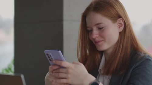 Beautiful Young Business Woman Using Phone in Office
