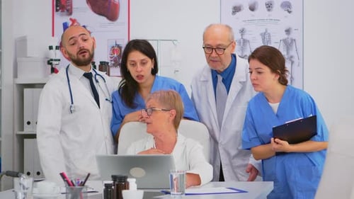 Medical Team Reviews Laptop in Bright Office