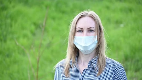 Mask on the Girl's Face To Protect Against the Virus Covid-19. Portrait of a Girl on a Green