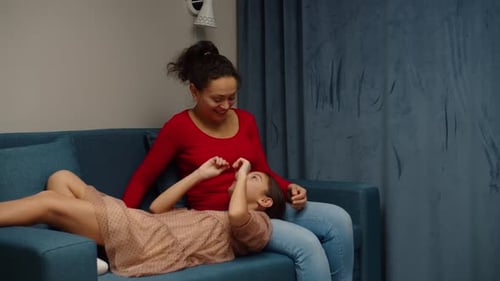 Young Woman and Girl Relaxing on Sofa